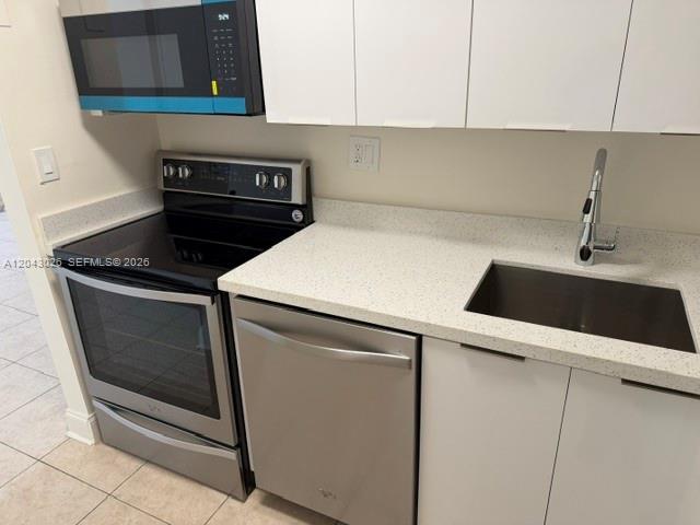 A kitchen features stainless steel appliances, white cabinets, and a light-colored speckled countertop — 8405 NW 8th St # 303, Miami FL 33126, MIAMI, FL