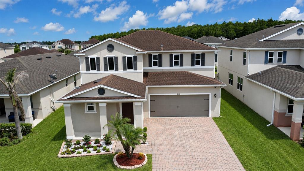 An aerial view of a two-story suburban house with a paved driveway and front landscaping — 3430 CANVAS STREET, KISSIMMEE, FL