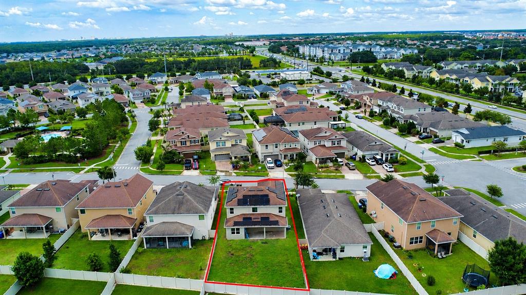 An aerial view shows a residential neighborhood with a highlighted house featuring rooftop solar panels — 3430 CANVAS STREET, KISSIMMEE, FL