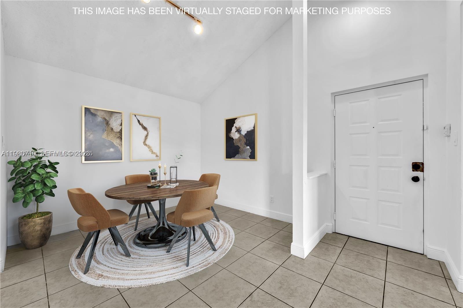 This virtually staged dining area features a round table, four chairs, and tile flooring — 15770 SW 106th Ter # 303, Miami FL 33196, MIAMI, FL