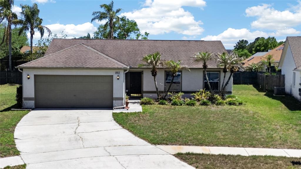 A single-story house with a two-car garage, stucco exterior, and a concrete driveway — 861 BLACKGUM COURT, ORLANDO, FL