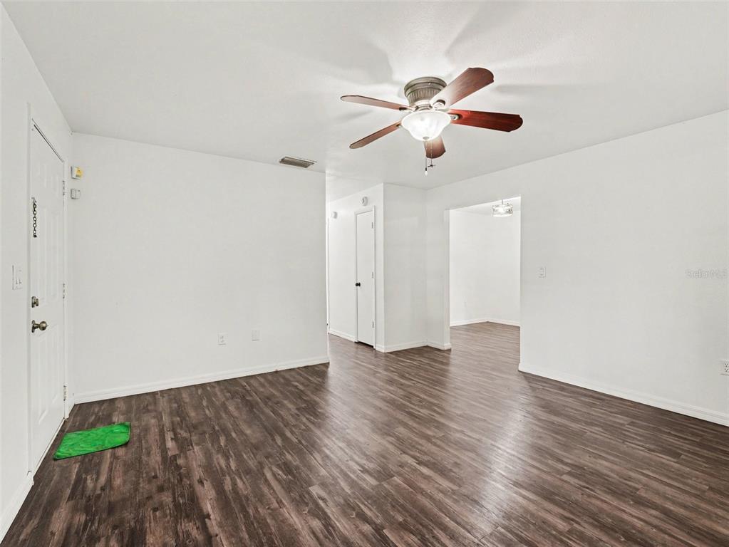 A living room with white walls, dark wood-look flooring, and a ceiling fan — 4042 HOMESTEAD DRIVE, LAKELAND, FL