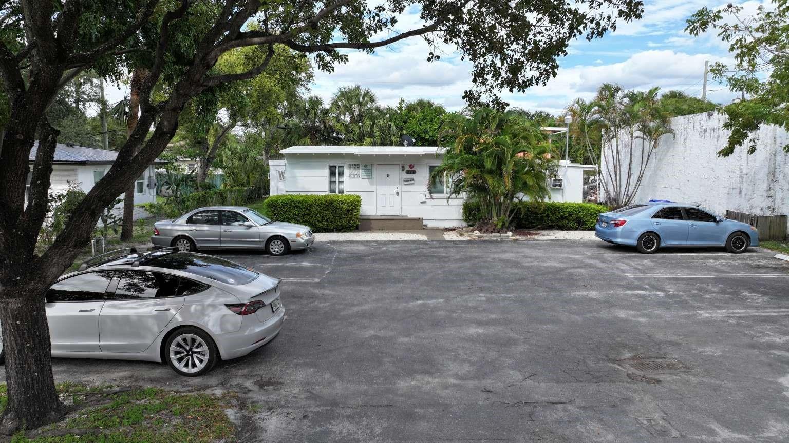A white single-story building sits behind a paved parking lot with three parked cars — 211 SW 2nd Court, Pompano Beach FL 33060, POMPANO BEACH, FL