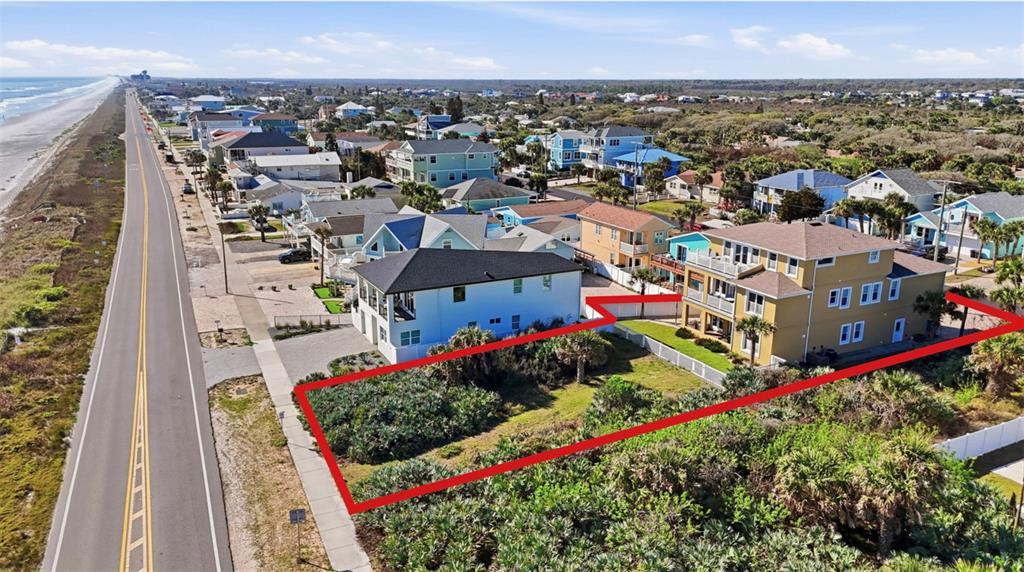 An aerial view shows a vacant, rectangular coastal lot outlined in red between two houses — 2208 S OCEAN SHORE BOULEVARD, FLAGLER BEACH, FL