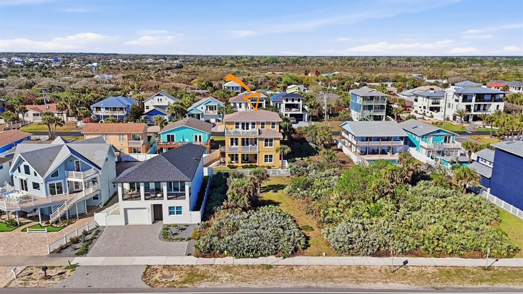 An aerial view shows a yellow three-story house surrounded by other coastal residential homes — 2208 S OCEAN SHORE BOULEVARD, FLAGLER BEACH, FL