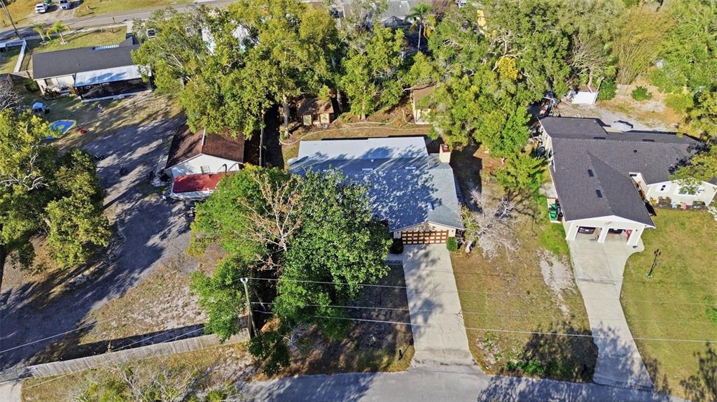 An aerial view shows a residential house with a gray roof and a concrete driveway — 244 ANGELES ROAD, DEBARY, FL