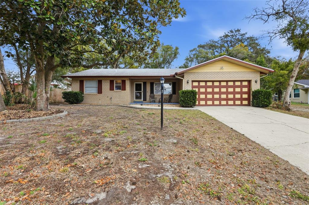 A single-story brick house with a two-car garage and a large front yard — 244 ANGELES ROAD, DEBARY, FL