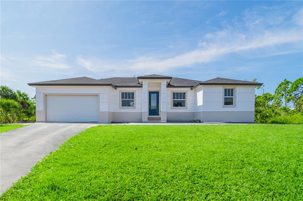 A single-story house with a white exterior, a two-car garage, and a green lawn — xx 15101 BRAINBRIDGE CIRCLE, PORT CHARLOTTE, FL