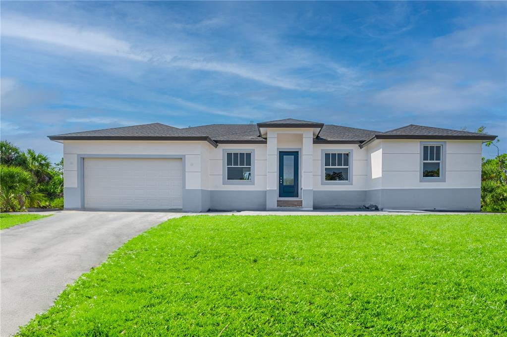 A single-story house with a white and gray exterior, a garage, and a front lawn — xx 15101 BRAINBRIDGE CIRCLE, PORT CHARLOTTE, FL