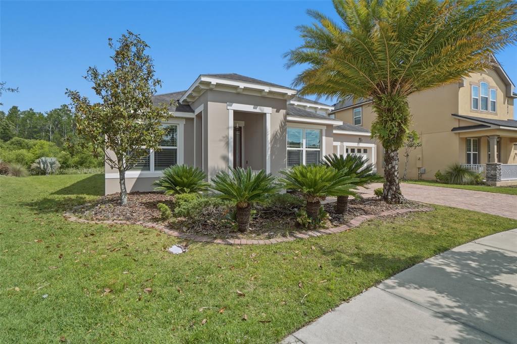 A single-story house with a beige exterior, a palm tree, and a landscaped front yard — 10760 TIBBETT STREET, ORLANDO, FL