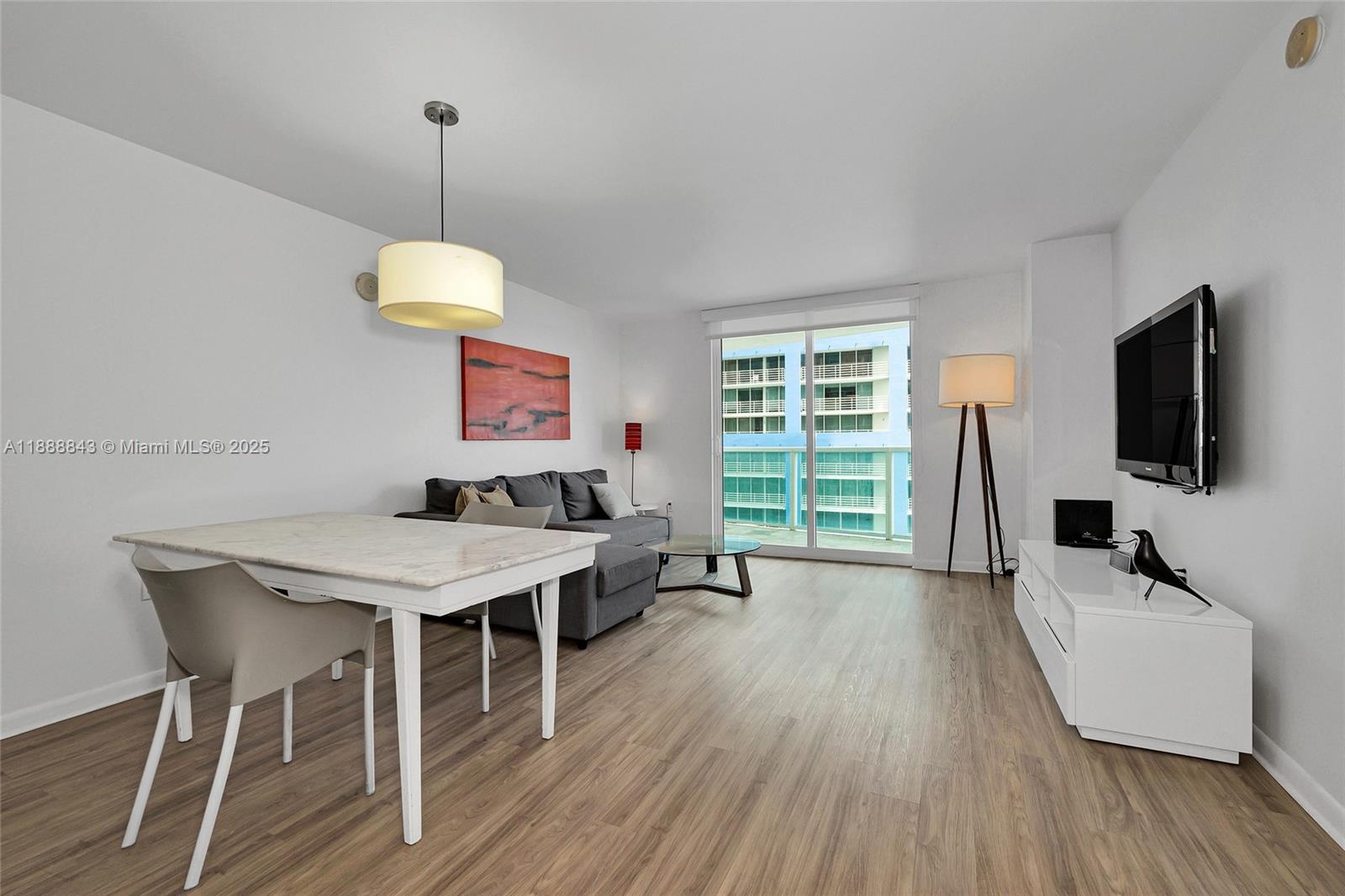 A living and dining area features a grey sofa, marble-topped table, and balcony view — 2101 BRICKELL AVENUE # 905, Miami FL 33129, MIAMI, FL