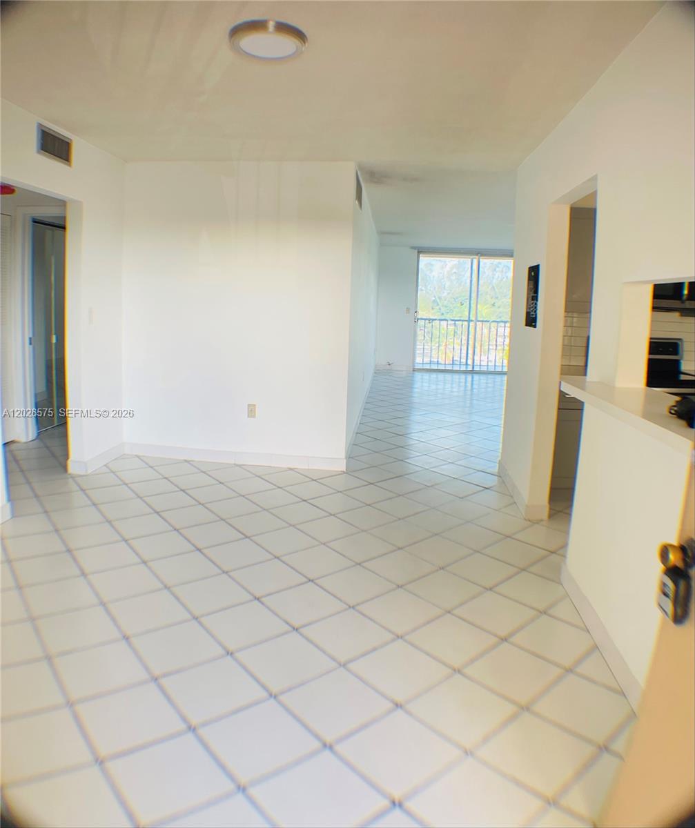 A tiled living area leads to a balcony with a sliding glass door — 12590 NE 16th Ave # 610, North Miami FL 33161, NORTH MIAMI, FL