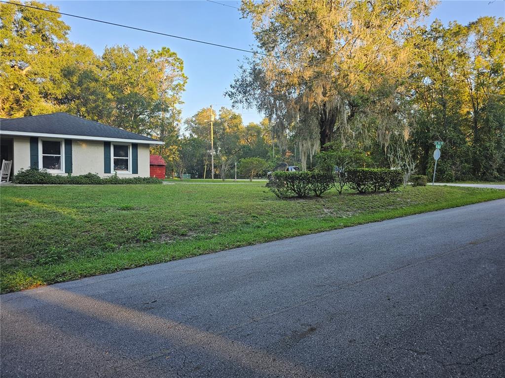 A single-story house with a lawn and trees sits beside a paved road — 5925 SE 165TH COURT, OCKLAWAHA, FL
