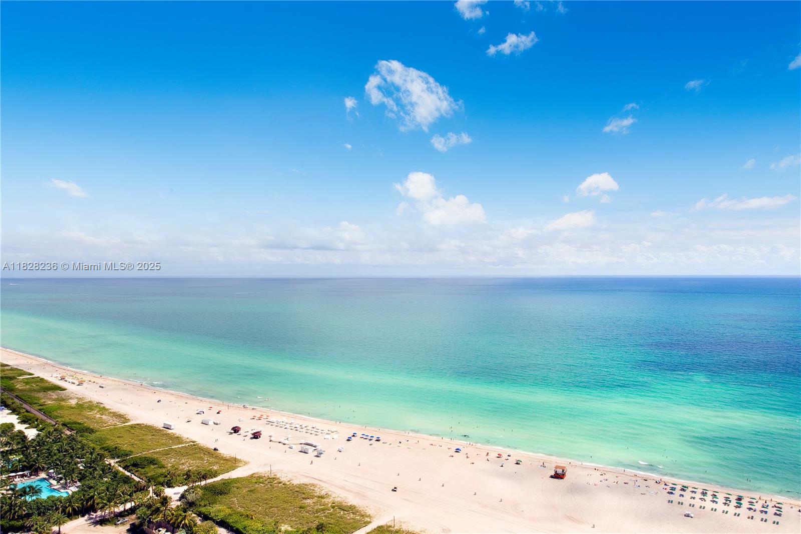 An aerial view shows a sandy beach along the turquoise ocean under a blue sky — 101 20th St # 3803, Miami Beach FL 33139, MIAMI BEACH, FL