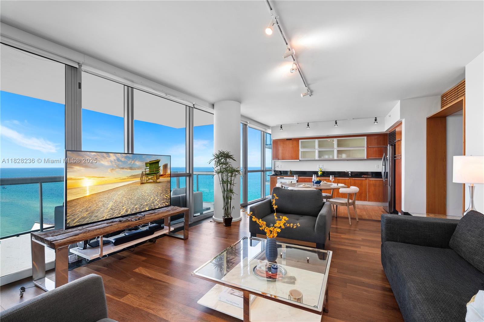 A living room with wood floors, a glass coffee table, and floor-to-ceiling ocean views — 101 20th St # 3803, Miami Beach FL 33139, MIAMI BEACH, FL
