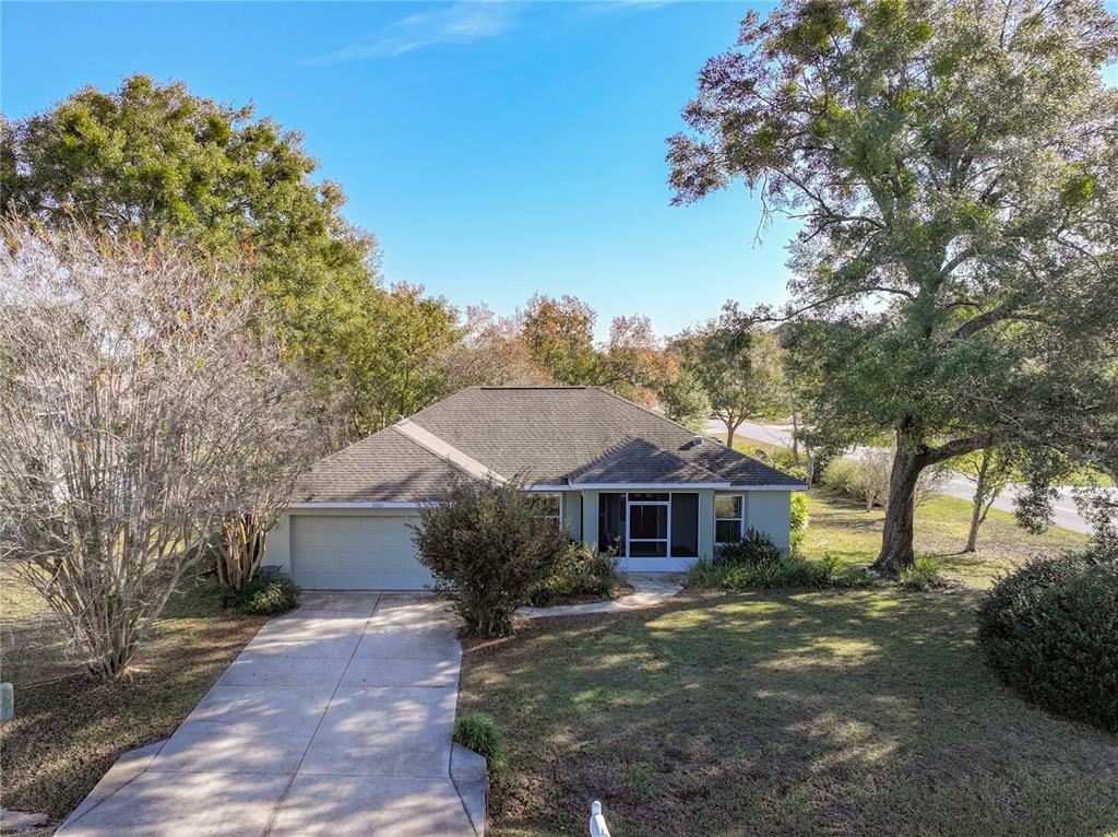 A single-story house with a two-car garage, a screened entryway, and a concrete driveway — 3061 NW 49TH AVENUE, OCALA, FL
