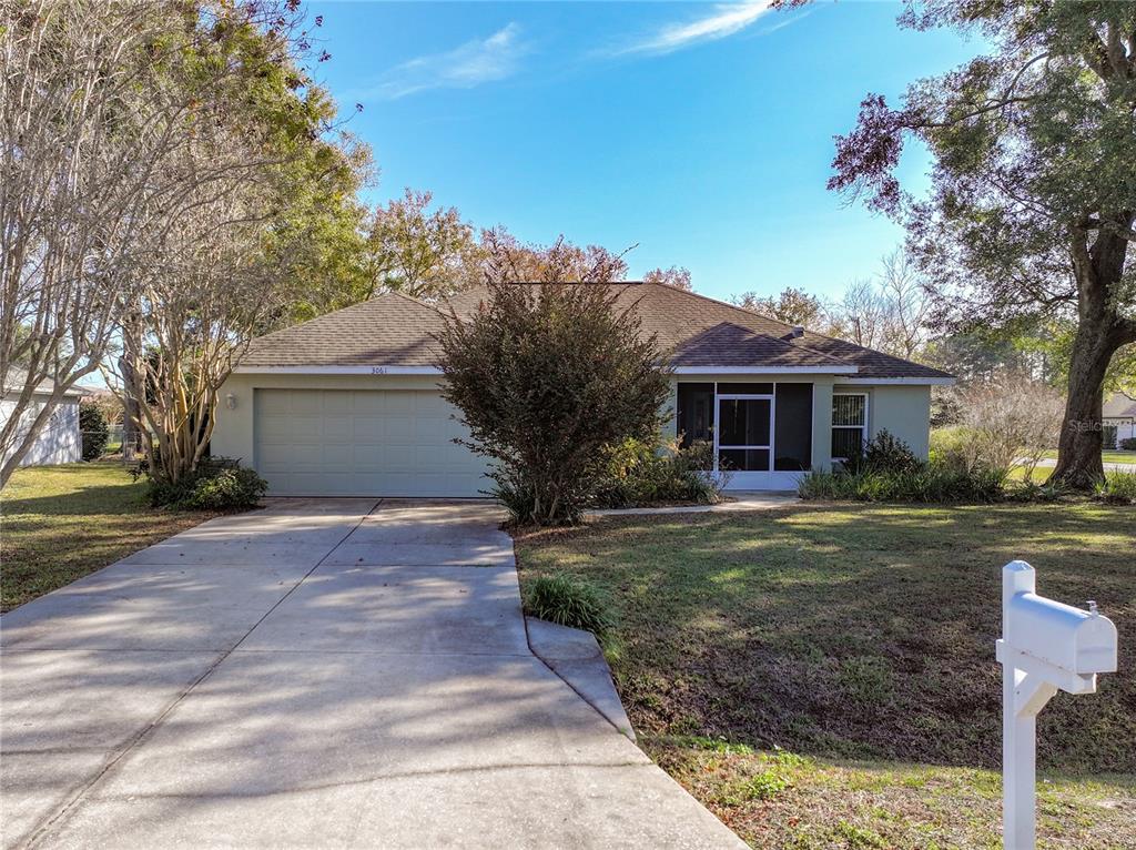 A single-story house with a two-car garage, a screened porch, and a concrete driveway — 3061 NW 49TH AVENUE, OCALA, FL