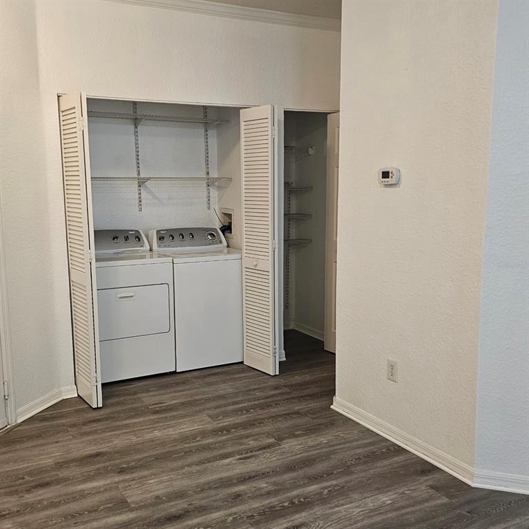 A laundry closet with a washer and dryer sits next to a small storage closet — 3599 CONROY ROAD UNIT 934, ORLANDO, FL