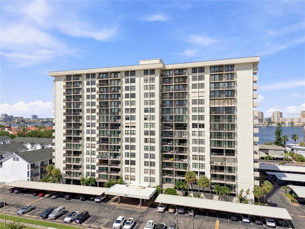 A multi-story residential apartment building with balconies and a covered parking lot — 400 ISLAND WAY UNIT 411, CLEARWATER, FL