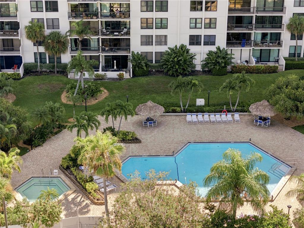 An aerial view shows a swimming pool, a hot tub, and lounge chairs by a building — 400 ISLAND WAY UNIT 411, CLEARWATER, FL