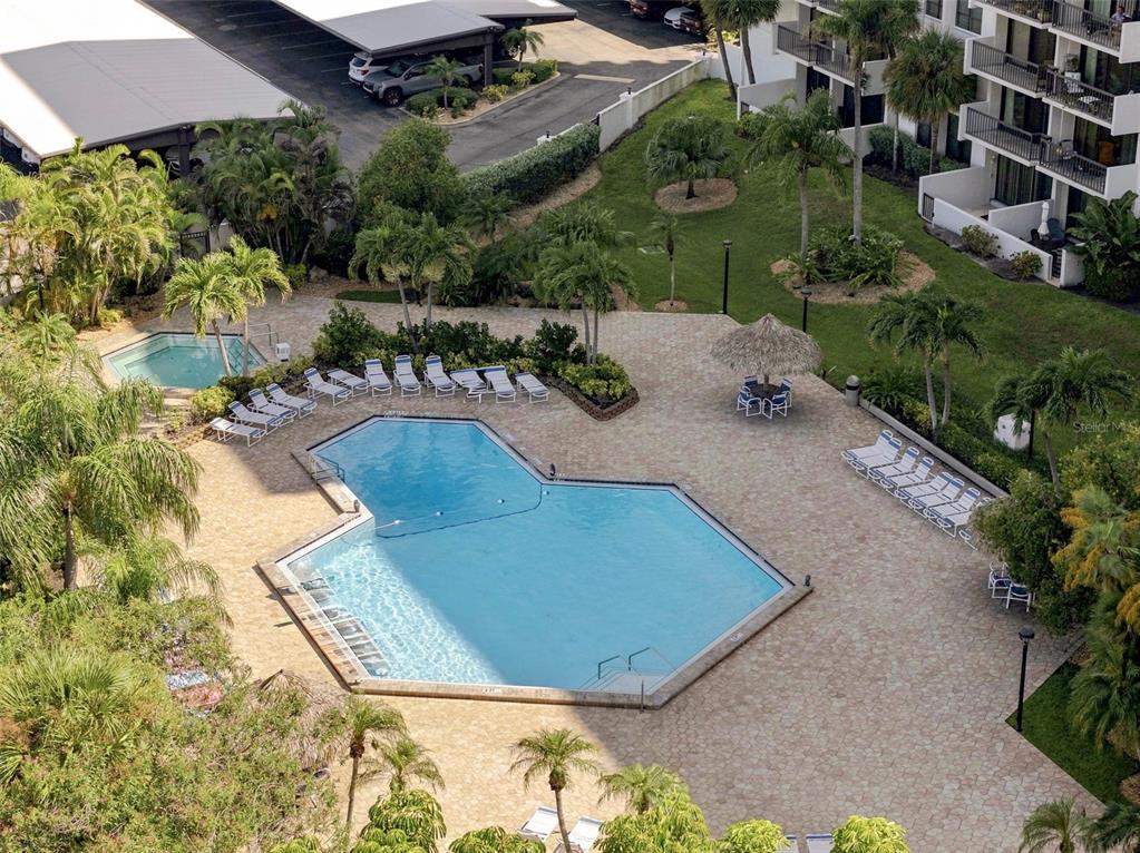 An aerial view shows a swimming pool, a hot tub, and lounge chairs on a patio — 400 ISLAND WAY UNIT 411, CLEARWATER, FL