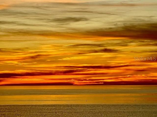 A vibrant orange and yellow sunset over a calm body of water — 5757 GULF OF MEXICO DRIVE UNIT 202, LONGBOAT KEY, FL