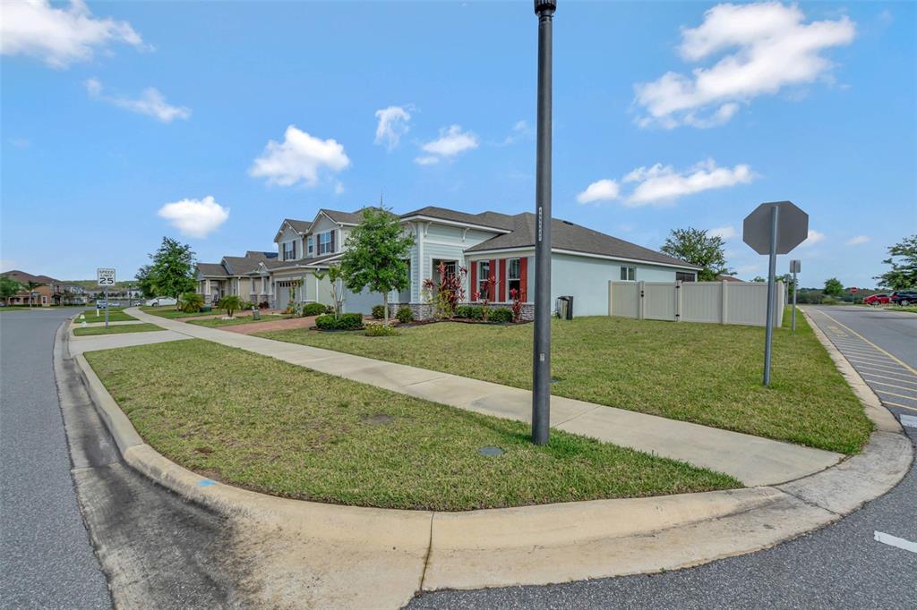 A view of a suburban house exterior with a lawn, sidewalk, and street corner — 3112 AMBERSWEET PLACE, CLERMONT, FL