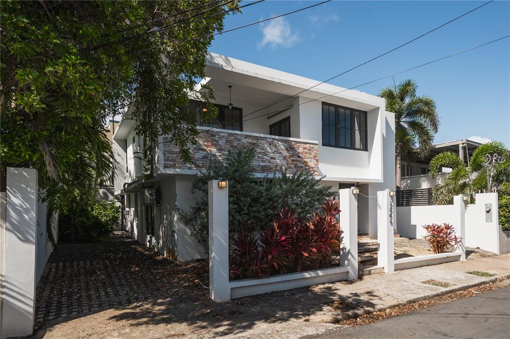 A two-story white house with a stone-accented balcony and a paved driveway — 2008 CACIQUE, SAN JUAN, PR