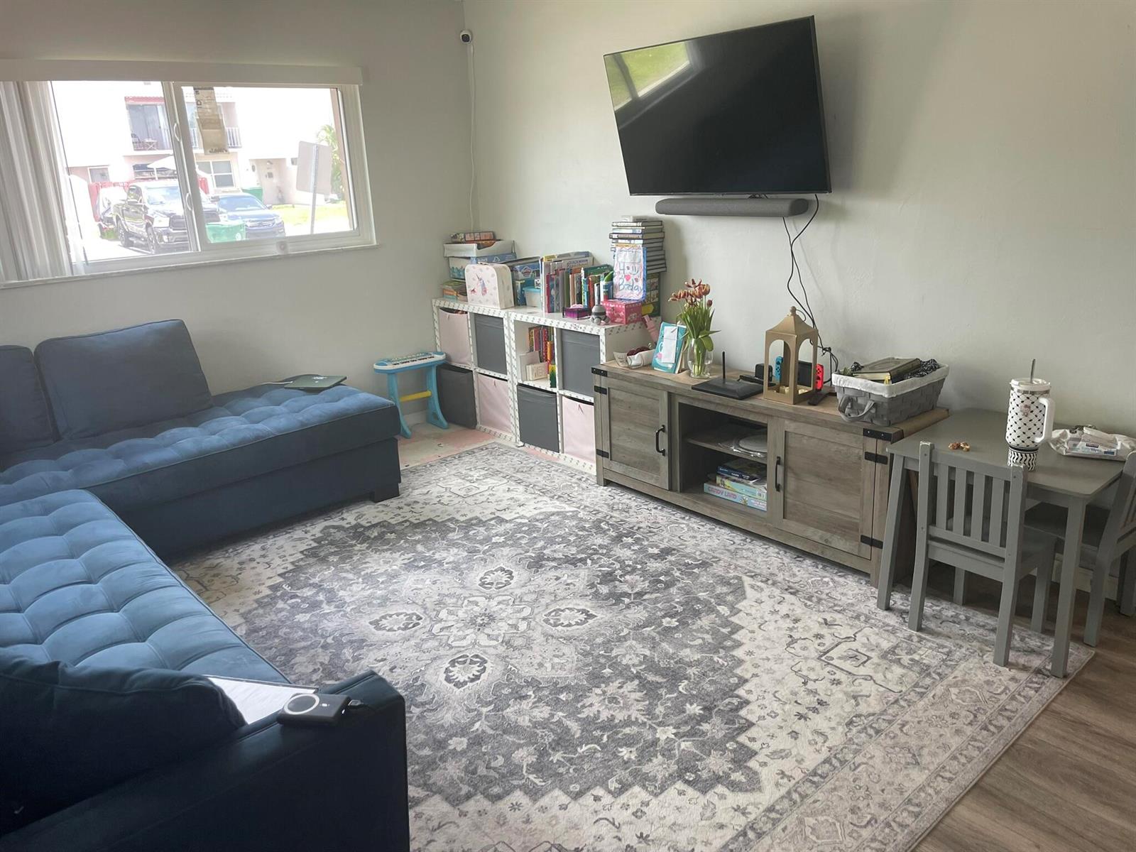 A living room features a blue sectional sofa, a patterned rug, and a media console — 3650 SW 59th Terrace # 80, Davie FL 33314, DAVIE, FL