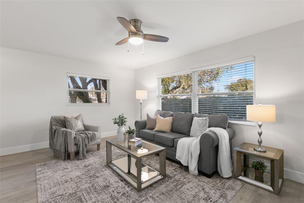 A living room features a gray sofa, an armchair, a coffee table, and a ceiling fan — 5931 DENVER STREET NE, ST PETERSBURG, FL