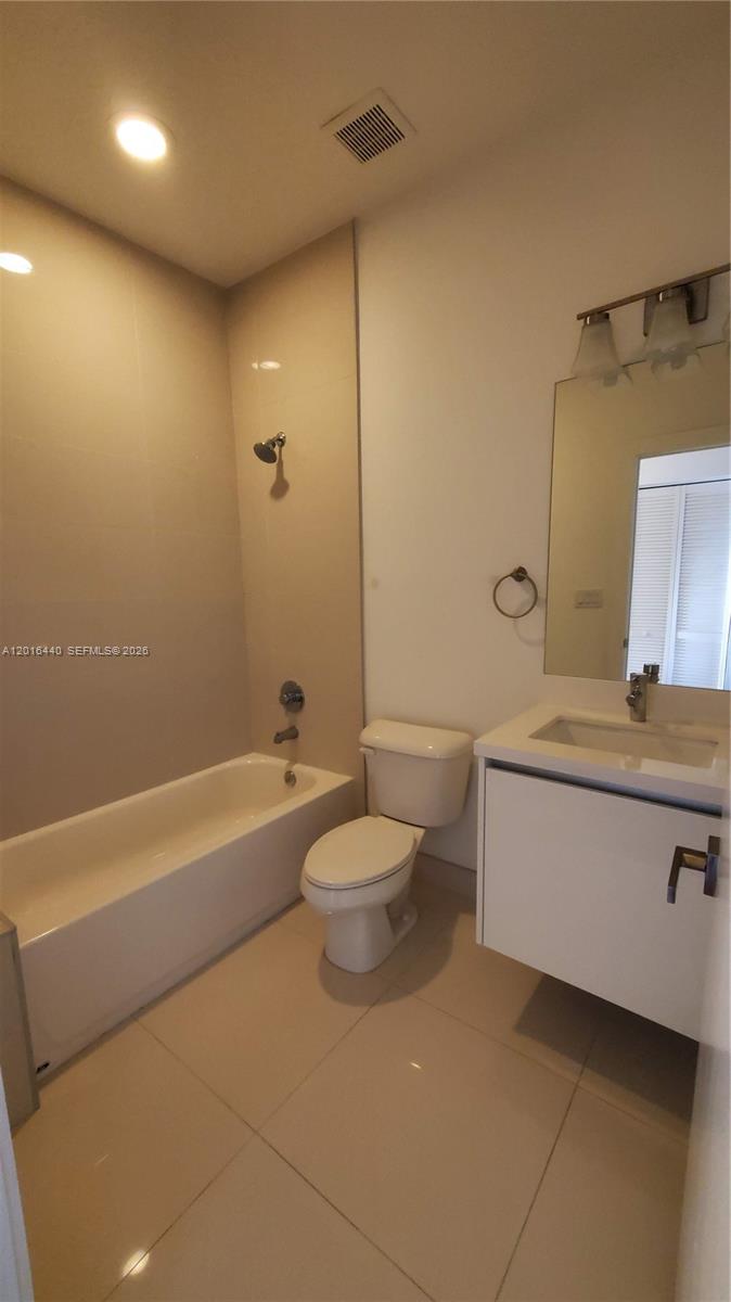 A bathroom features a white vanity, a toilet, and a bathtub with a shower head — 7210 NW 103rd Path, Doral FL 33178, DORAL, FL