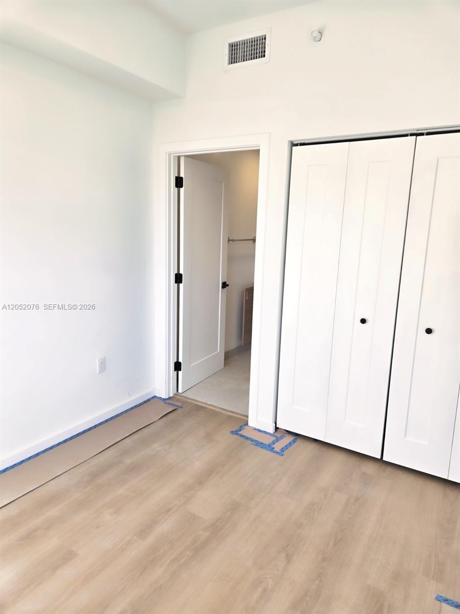 A room with light wood-look flooring, white walls, a closet, and an open doorway — 8106 NE 1st Ave # 8, Miami FL 33138, MIAMI, FL