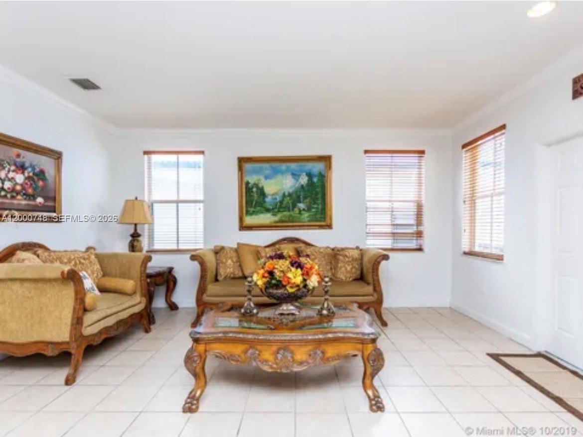 A living room features beige tile floors, two ornate sofas, and a central coffee table — 8135 NW 198th Ter, Hialeah FL 33015, HIALEAH, FL