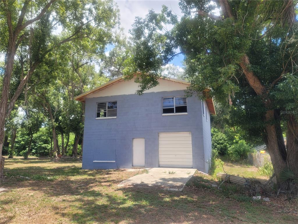 A two-story blue concrete block building with a garage door and two upper-level windows — 510C TIGHE STREET, SEFFNER, FL
