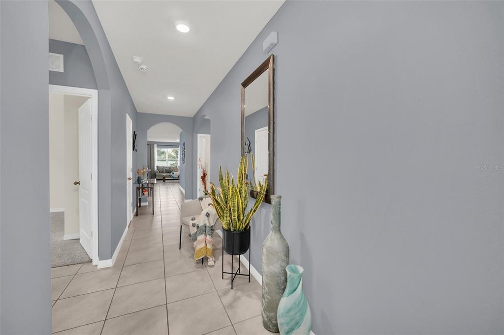 A hallway with gray walls, tile flooring, a tall mirror, and a potted snake plant — 3308 COUNTRY WALK CLUB CIRCLE, WINTER HAVEN, FL