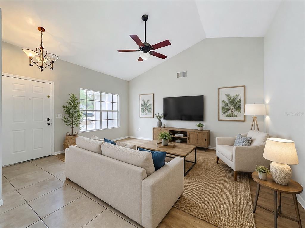 A dining room features a wooden table, six gray chairs, a chandelier, and a mirror — 925 OLD MAIL LANE, SANFORD, FL