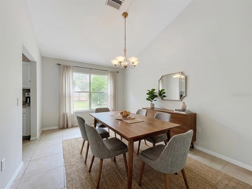 A bedroom features a queen bed, a blue armchair, wood-look flooring, and a ceiling fan — 925 OLD MAIL LANE, SANFORD, FL