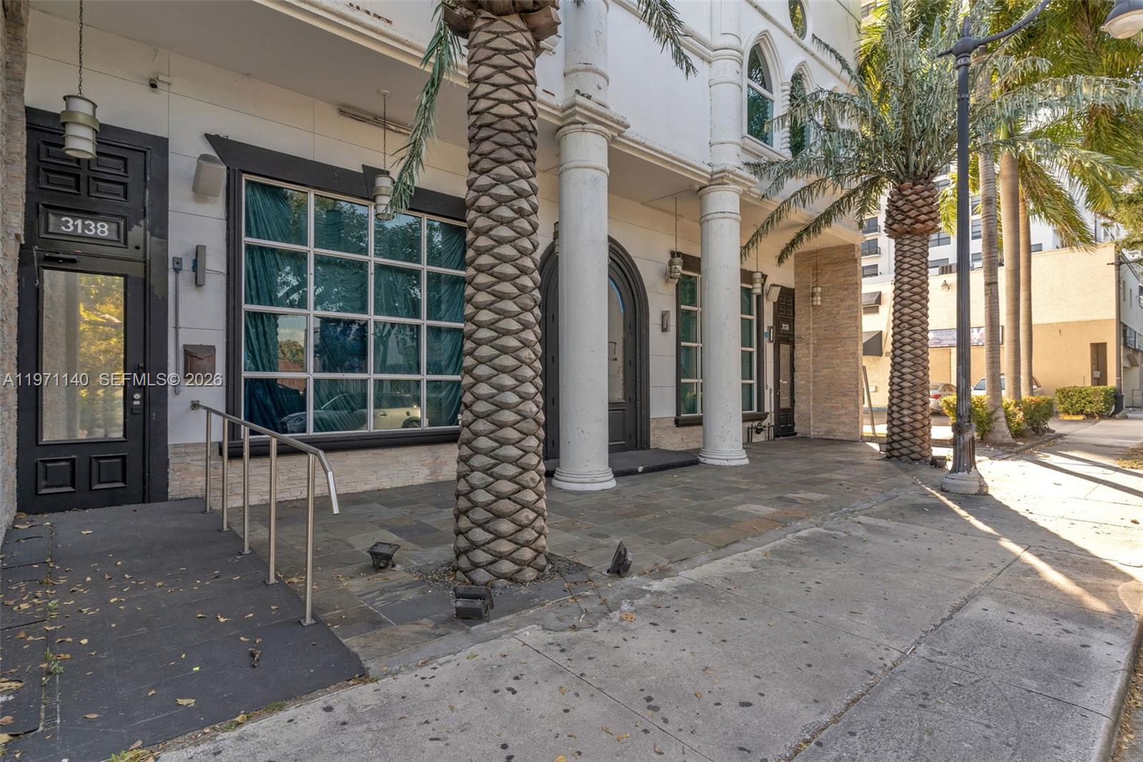 The exterior of a building features white columns, large windows, and palm trees on a sidewalk — 3138 Coral Way, Miami FL 33145, MIAMI, FL