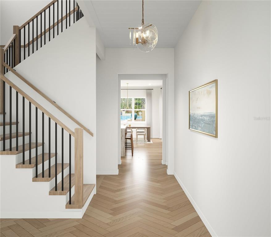 This rendering shows a foyer with a staircase, herringbone wood floors, and a glass chandelier — 714 W FRANCES AVENUE, TAMPA, FL