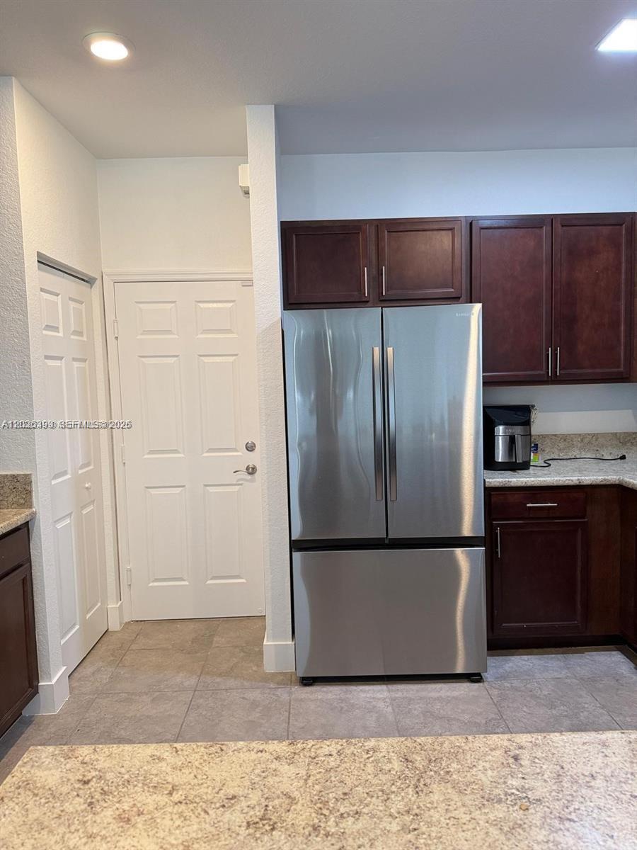 A kitchen features dark wood cabinets, stainless steel appliances, and light-colored granite countertops — 156 NE 24th Ave, Homestead FL 33033, HOMESTEAD, FL