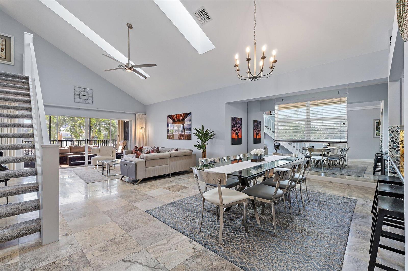 A bright, open-concept living and dining area features vaulted ceilings, tile floors, and a staircase — 4161 S. Us Highway 1 # G3, Jupiter FL 33477, JUPITER, FL