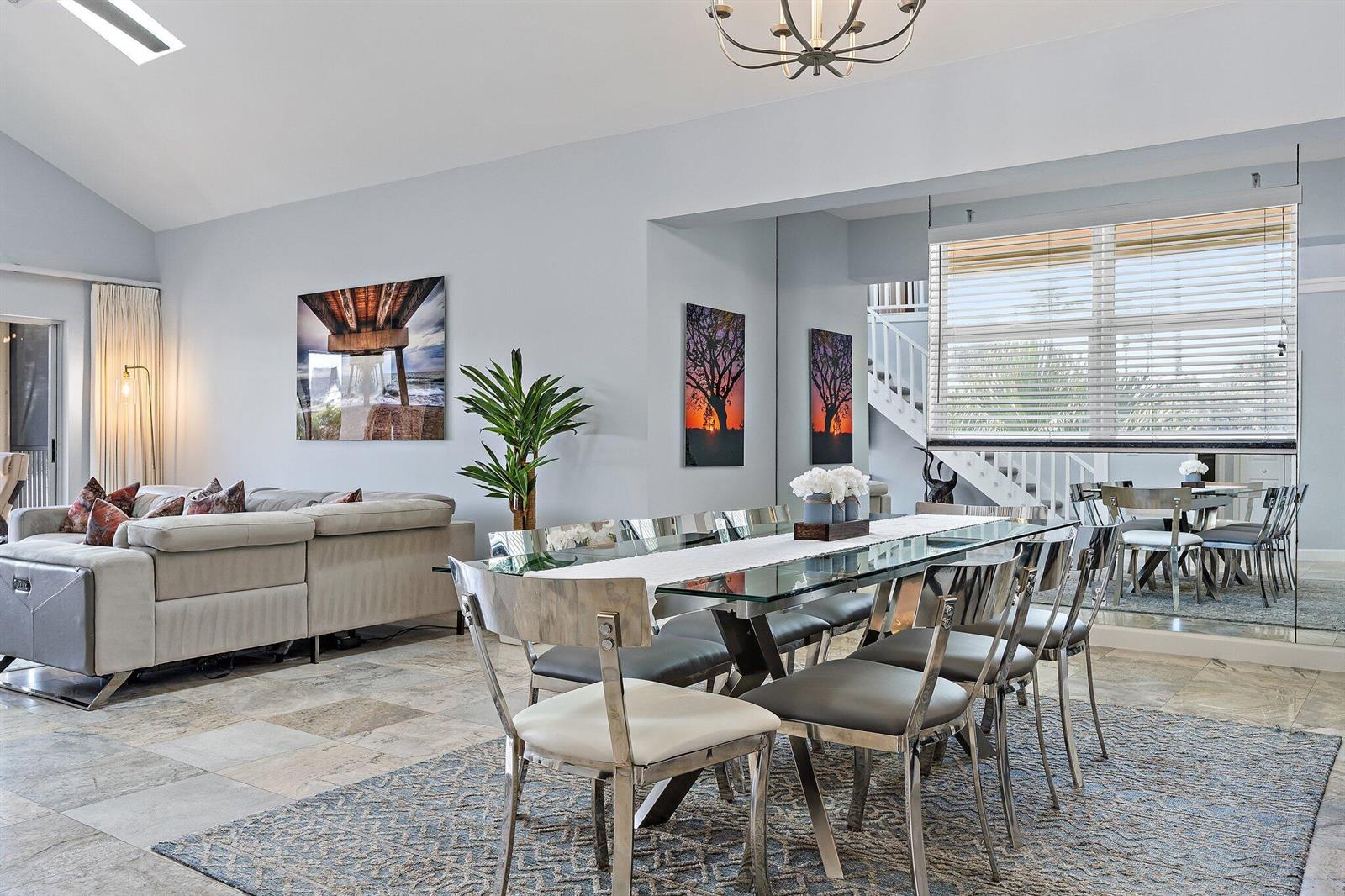 A dining area with a glass table and metal chairs sits beside a living room — 4161 S. Us Highway 1 # G3, Jupiter FL 33477, JUPITER, FL