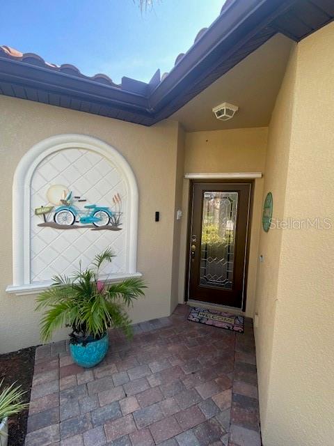 A paved entryway features a front door with glass inlay and a decorative wall niche — 6760 WILLOWSHIRE WAY, BRADENTON, FL