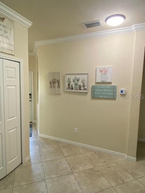 A hallway with beige walls, tile flooring, and several pieces of wall art — 6760 WILLOWSHIRE WAY, BRADENTON, FL