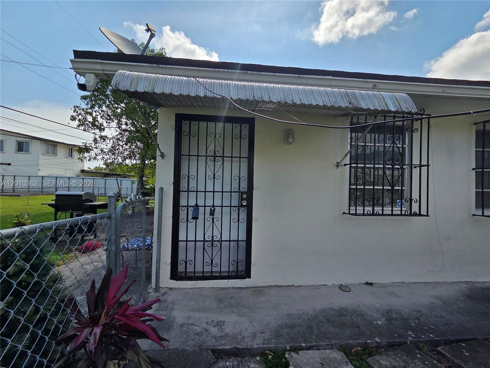 The exterior of a house features a metal security door, window bars, and an awning — 11035 SW 56th St # B, Miami FL 33165, MIAMI, FL