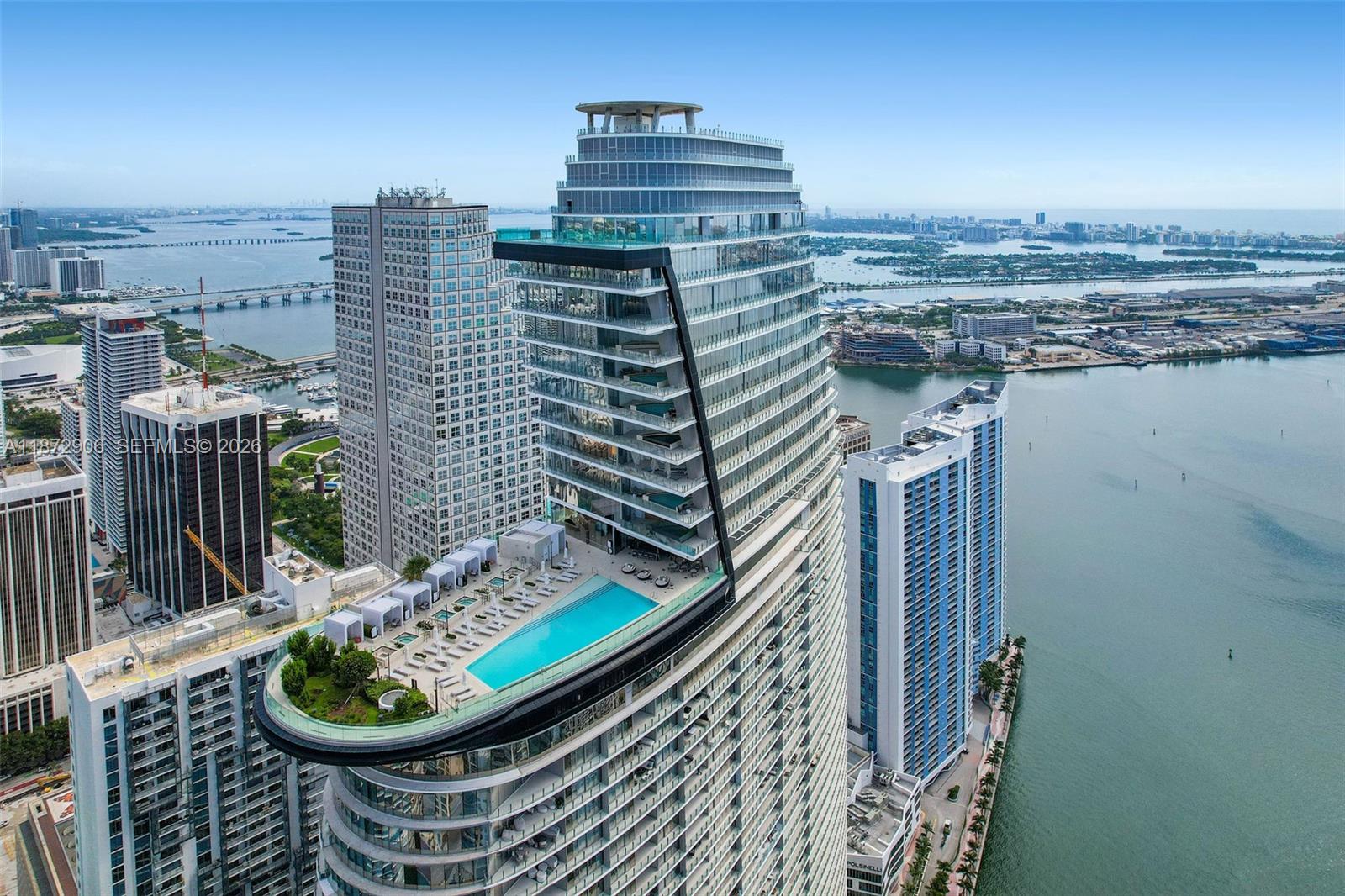 An aerial view shows a high-rise building featuring a rooftop swimming pool and terrace — 300 Biscayne Blvd Way, Miami FL 33131, MIAMI, FL