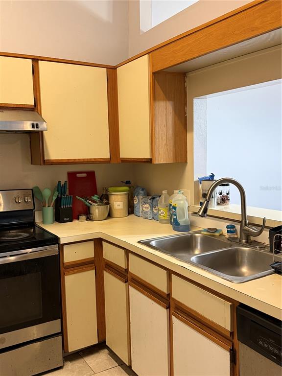 A kitchen features light-colored cabinets with wood trim, a stainless steel sink, and a stove — 3916 MAGNOLIA LAKE LANE, ORLANDO, FL