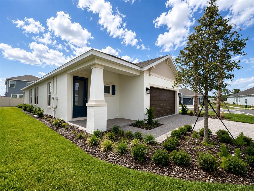 A single-story house exterior features a brown garage door, a paved driveway, and a porch — 994 TEAL CREEK DRIVE, ST CLOUD, FL