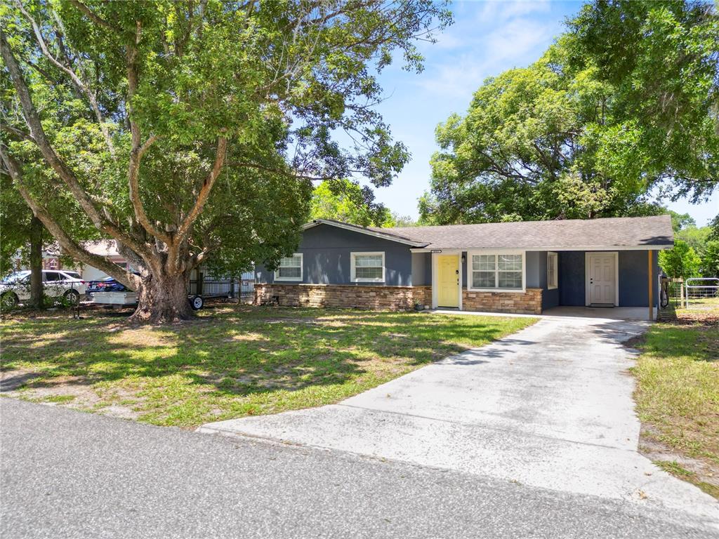 A single-story house with gray siding, a stone facade, and a yellow front door — 4561 DAVID DRIVE, BARTOW, FL