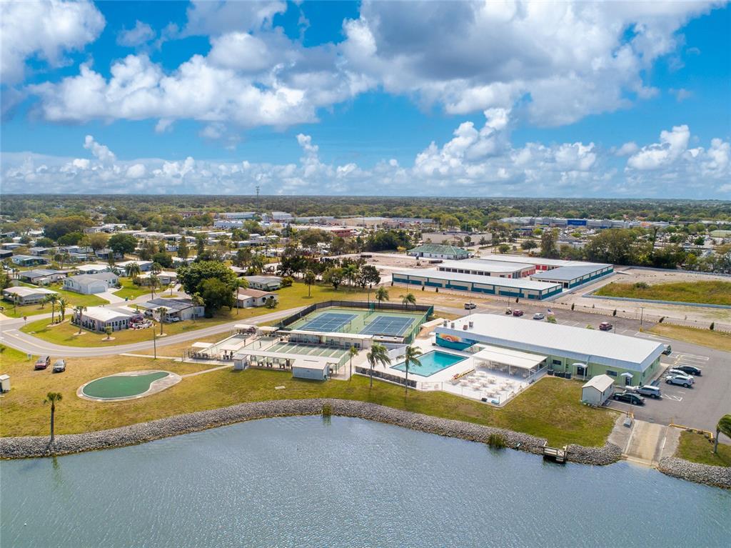 An aerial view shows a community center with tennis courts, a pool, and a lake — 6257 BUNTING LANE, ENGLEWOOD, FL